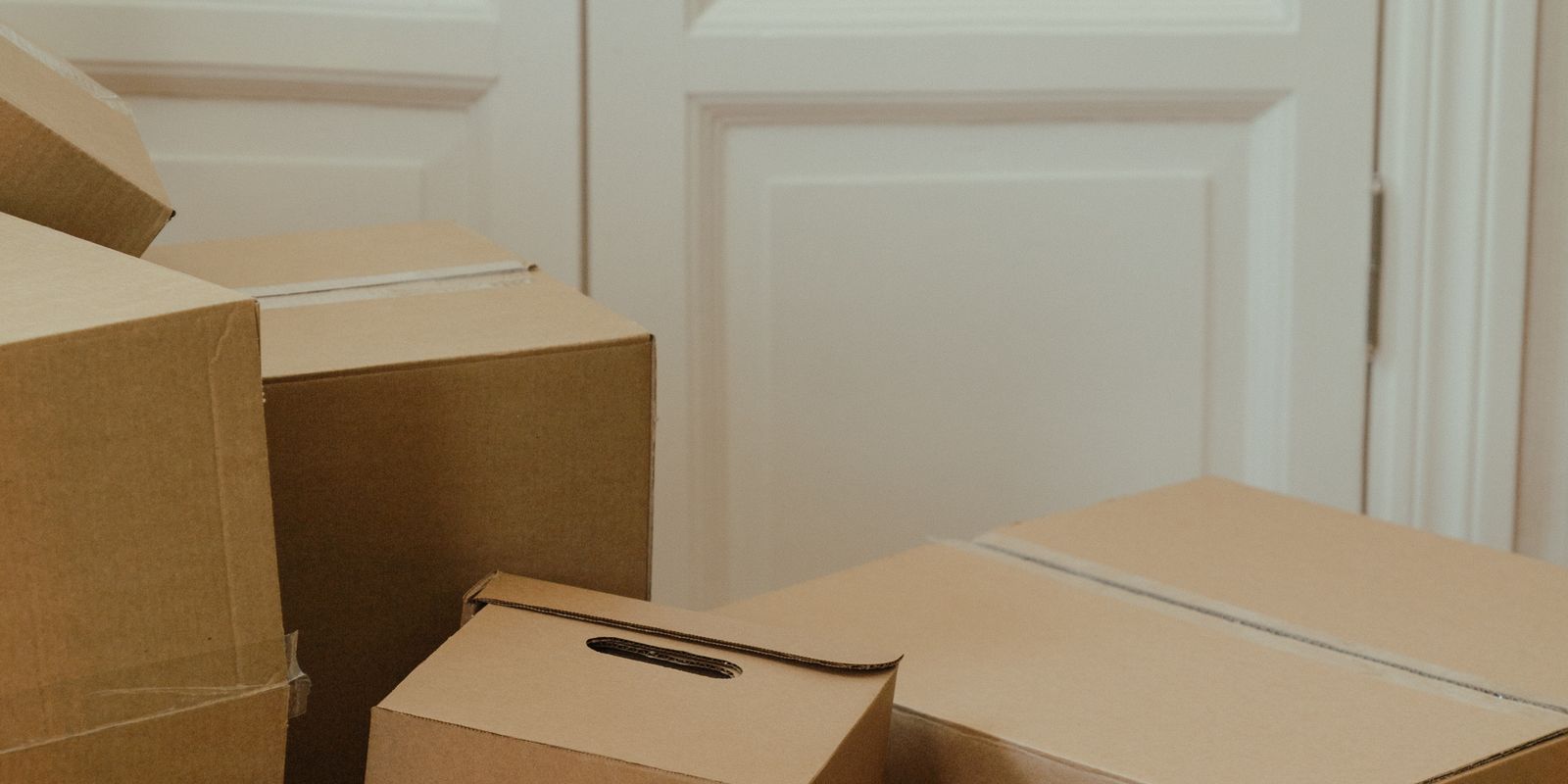 A stack of moving boxes just inside the door of a rented apartment