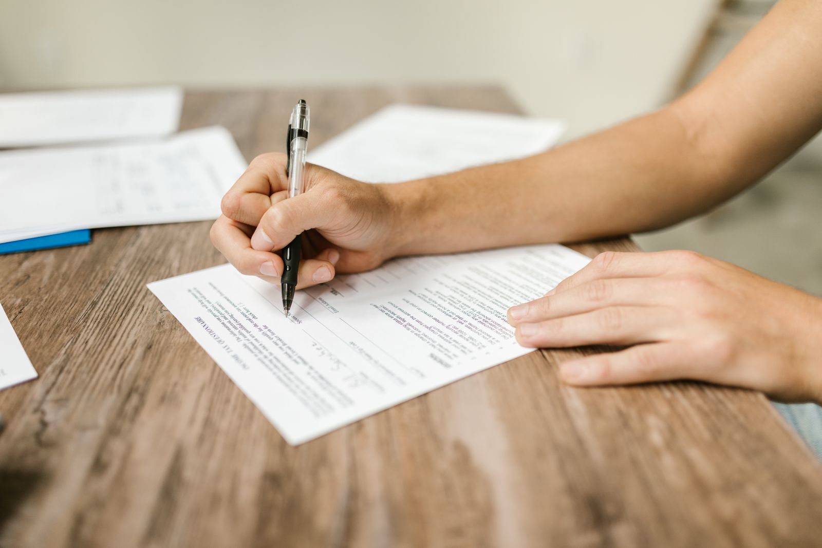 Close-up of a person filling out a claim form by hand